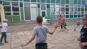 Dzieci odbijają piłkę na dworze