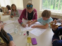 Bibliotekarka wspiera pracę dziecka rysującego komiks