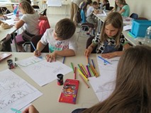 Chłopiec i dziewczynka kolorują okładkę komiksu