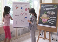 Dwie dziewczynki rysują po tablicy markerem