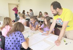 Dzieci rysują Komiks, a pan prowadzący warsztaty tłumaczy im techniki rysownicze