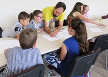 Dzieci w grupie rysują komiks, a pan Artur Wabik kieruje ich pracą