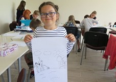 Dziewczynka pozuje ze swoją pracą