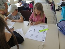 Dziewczynka rysuje postaci w komiksie