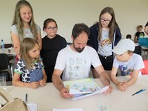 Pan Artur ocenia okładki podczas gdy dzieci stoją naokoło niego