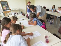 Pan Artur Wabik pomaga dzieciom w tworzeniu komiksu