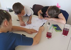 Troje dzieci pracuje nad komiksem