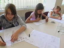 Trzy dziewczynki są w trakcie rysowania komiksu