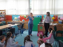 Dwie bibliotekarki pokazują dzieciom gestem co robią, a dzieci odgadują