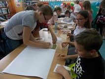 Dzieci w grupach tworzą plakaty