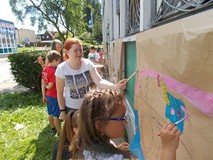 Bibliotekarka pomaga dzieciom podczas pracy plastycznej