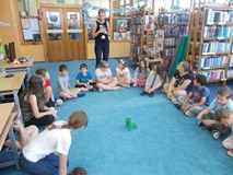 Dzieci siedza w kręgu wykonąc wylosowane zadania