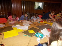 Dzieci przy stołach podczas zabawy plastycznej