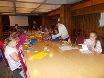 Dzieci przy stole wykonują prace plastyczne