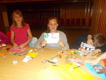 Dziewczynka pozuje z wykonaną pracą plastyczną