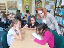 Bibliotekarka obserwuje dzieci podczas zabawy przy stoliku