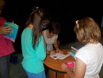 Pisarka podpisuje dzieciom książki