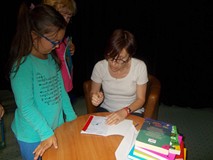 Pisarka podpisuje dzieciom książki