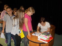 Pisarka podpisuje dzieciom książki