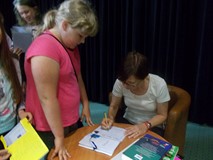 Pisarka podpisuje dzieciom książki