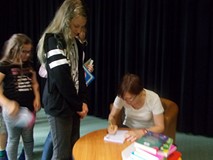 Pisarka podpisuje dzieciom książki