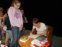 Pisarka podpisuje dzieciom książki