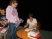 Pisarka podpisuje dzieciom książki