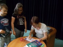 Pisarka podpisuje dzieciom książki