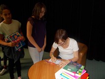 Pisarka podpisuje dzieciom książki