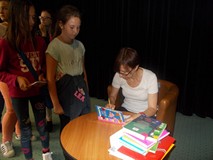 Pisarka podpisuje dzieciom książki