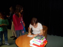 Pisarka podpisuje dzieciom książki