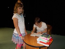 Pisarka podpisuje dzieciom książki