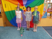 Trzy dziewczynki pozują do zdjęcia z rekwityzami z papieru