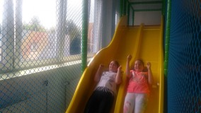 Dwie dziewczynki zjeżdżają ze zjeżdżalni