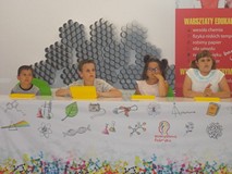 Czwórka dzieci słucha ciekawostek dotyczących chemii
