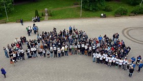 Na zdjęciu z góry widoczna  na placu przed biblioteką  bardzo liczna grupa ludzi z napisem 