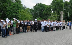 Na placu przed biblioteką bardzo liczna grupa młodych mężczyzn - uczniów Zespołu Szkól nr 9z napisem