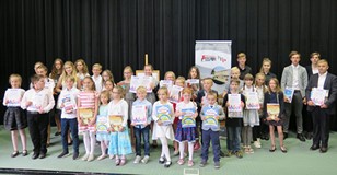 Na zdjęciu na scenie stoi liczna grupa finalistów Regionalnego turnieju recytatorskiego 