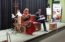 Na scenie aktorzy amatorskiego teatru Recepta w scence z przedstawienia ECCE HOMO siedzą na ławce i 