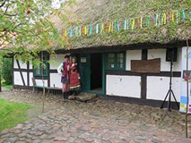 W czasie Narodowego Czytania 2017 w Koszalinie młoda para w strojach ludowych pozuje do zdjęcia na t