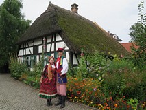 W czasie Narodowego Czytania 2017 w Koszalinie młoda para w strojach ludowych pozuje do zdjęcia na t