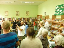 Koszalińskie media dokumentują wernisaż, malarka podziwia otrzymane kwiaty