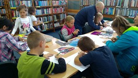 Dzieci wykonują prace plastyczne na temat Londynu, podczas gdy rodzic wspiera ich pracę