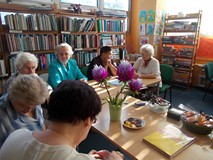 Panie siedzą przy stole i rozmawiają