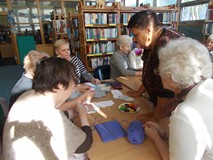 Panie oglądają swoje prace rękodzielnicze