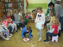 dzieci  ucierają ziarenka na mąkę