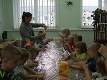 dzieci lepią bułeczki z ciasta