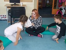 Bibliotekarka pokazuje fragment w książce dziewczynce i chłopcu