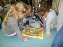 Trójka dzieci ogląda książeczkę