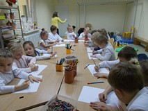 Przedszkolaki pod opieką wychowawczyni przy pracy plastycznej